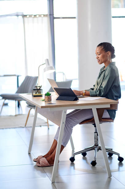 istock Cheerful woman working with digital devices in home office 1715472539