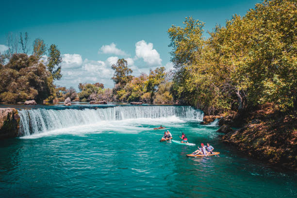 istock A group of white people floating on a supboard around the waterfall in the river 1715479215