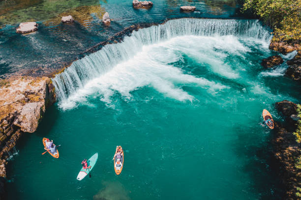 istock A group of white people floating on a supboard around the waterfall in the river 1715483183