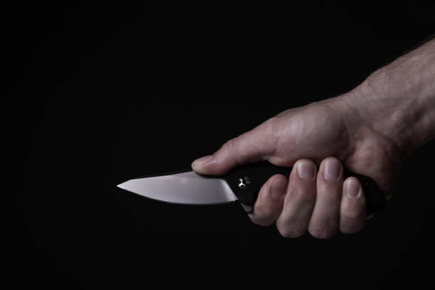 istock A sharp knife in the man's hand. The use of cold weapons. Knife attack . Armed raid. 1715502314
