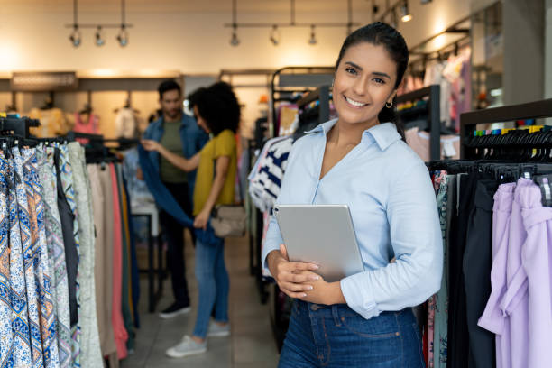 szczęśliwy właściciel firmy uśmiecha się w sklepie odzieżowym - boutique store owner latin american and hispanic ethnicity zdjęcia i obrazy z banku zdjęć