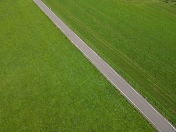 istock Aerial view of a road between grass fields in the landscape 1715504576