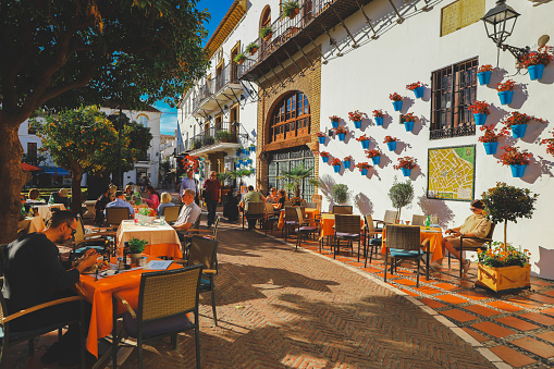 Marbella, Spain - November 20, 2021 - Tourists relaxing at pavement cafes and restaurants in Orange Square, Marbella, Malaga