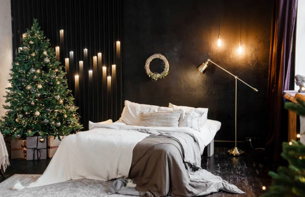 Bedroom interior decorated for Christmas holidays. Home interior with a Christmas tree on a dark wall background. stock photo