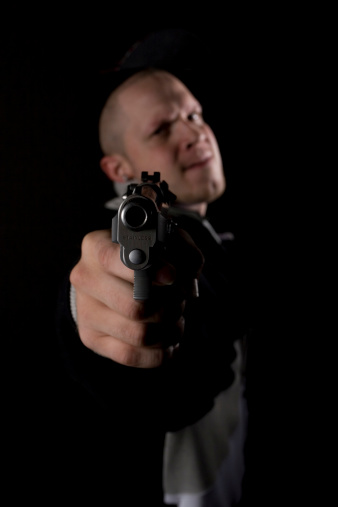 Man being murdered with handgun on a dark background