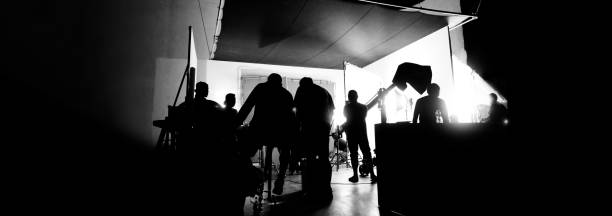 Silhouette images of making of or behind the scenes of video production which produced in the film studio that include all pro light and camera equipment and professional film crew with movie director imágenes de siluetas de la realización o detrás de escena de la producción de video que se produjo en el estudio de cine que incluyen todo el equipo de luz y cámara profesional y el equipo de filmación profesional con el director de la película