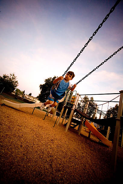 istock young child playing on swing in park 171554050