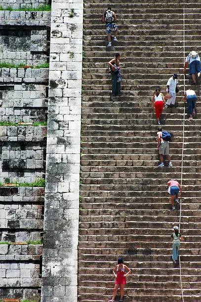 "Tourists climb the steps of the Great Pyramid at Chichen-Itza, Mexico"