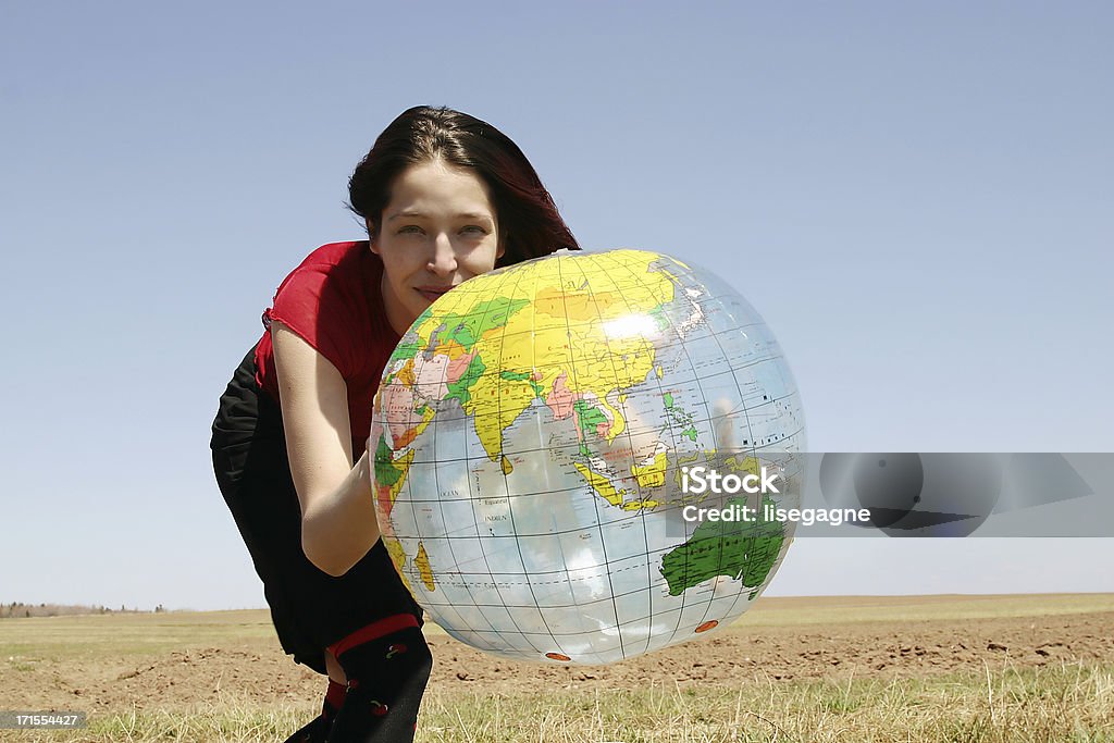 Kobieta trzyma Piłka plażowa świecie - Zbiór zdjęć royalty-free (Bezchmurne niebo)