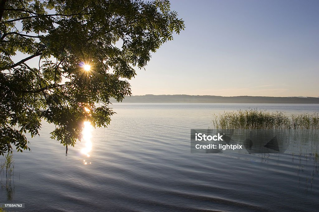 Lakeside sunrise Early morning sun reflection on a lakePlease see some similar pictures from my portfolio: In Silhouette Stock Photo