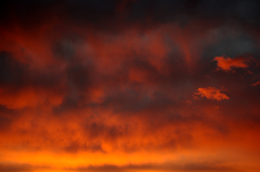 Dramatic dark sky with orange clouds at a sunset
