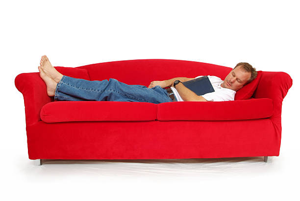 istock Middle Aged Man with a Book Sleeping on Red Couch 171555122