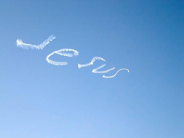 Stock photo showing close-up, elevated view of background of soft, dry golden beach sand with gold lettering spelling 'love'.