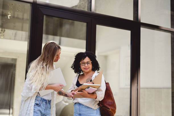 istock female student showing test results to each other. 1715552935