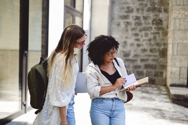 istock student communicating with her professor. professor in conversation with a student and examining a workbook. 1715553479