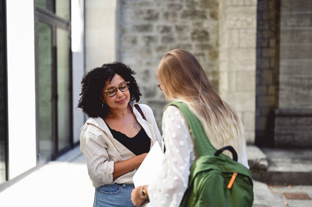 istock University teacher talking and discussing problems with a female student. 1715554022