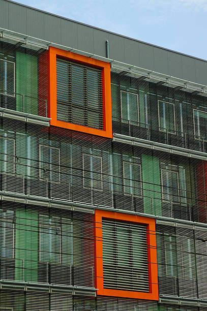 Green building in Heidelberg "Facade of this environmentally sustainable building in Heidelberg captivated my attention.  Beautiful composition and simple design.  Orange framed windows stand out against the green tinted glass.  Louvered windows provide needed shading to lower solar heating of the building during hot summer months and help regulate energy consumption in the building.View of a hillside castle in Heidelberg, Germany.Heidelberg is a city in Baden-W" heidelberg germany stock pictures, royalty-free photos & images