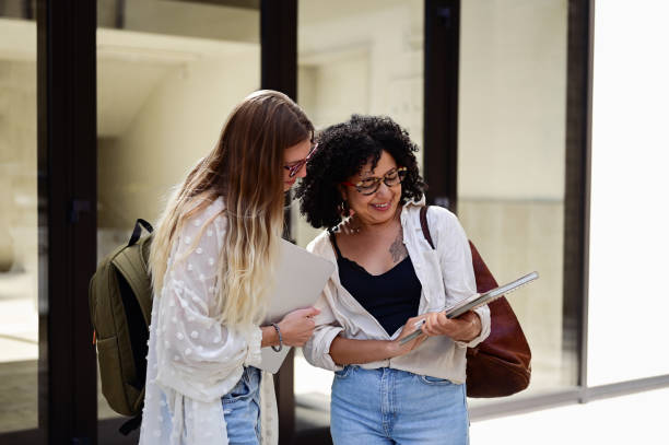 istock Multiracial students looking at workbook at a University campus or office. 1715555217