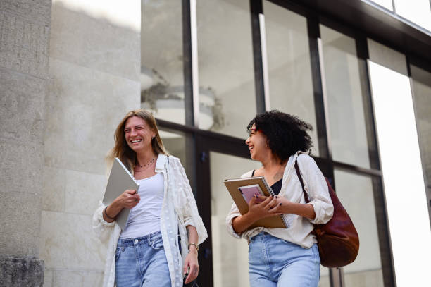 istock Two female adults students walking on the streets and laughing. 1715555747