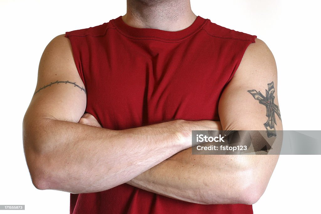 Solide homme avec des tatouages et les bras croisés. Bourreau. Chemise rouge. - Photo de Fil barbelé libre de droits