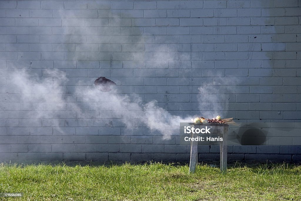 Smoking barbecue Smoking barbecue against a wall Barbecue Grill Stock Photo