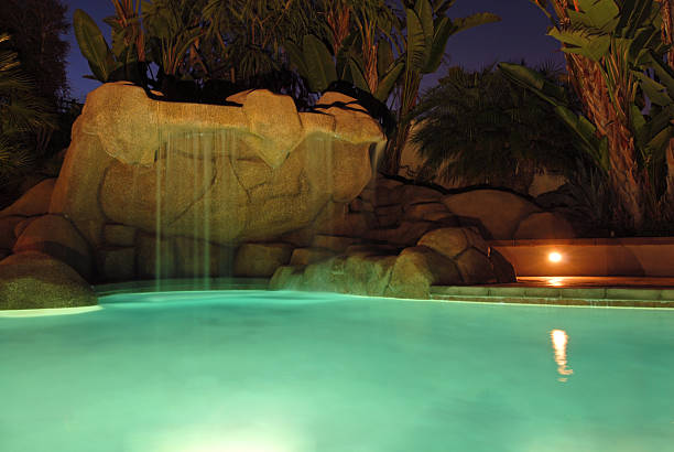 Pool at night Pool with rock features at night. victoria beckham stock pictures, royalty-free photos & images