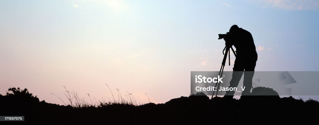 Panoramic Photographer at Sunrise A photographer is a silhouette at the top of a mountain at an early morning sunriseOther Related Pictures in my portfolio: Achievement Stock Photo