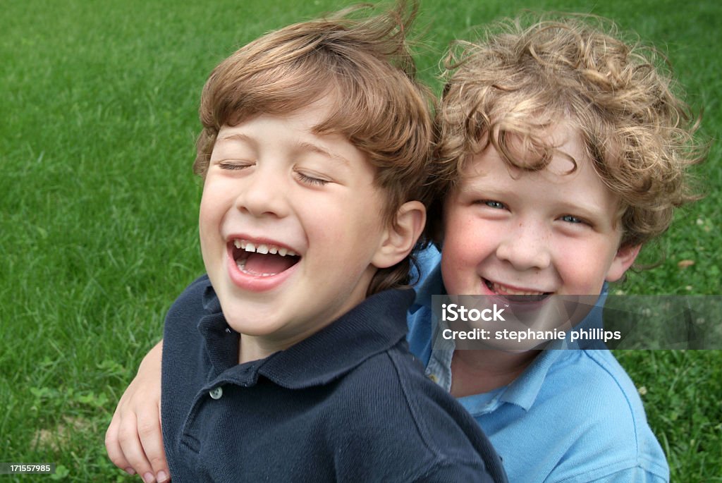 Dos hermanos abrazándose y riéndose al aire libre en el verano - Foto de stock de Abrazar libre de derechos