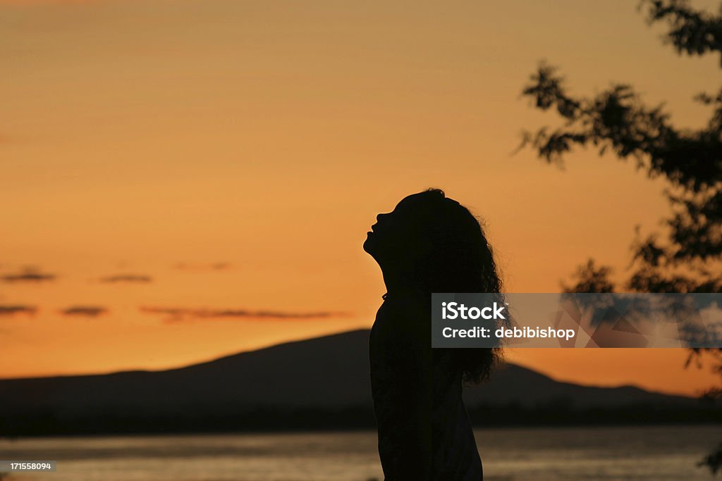 Silhouette di donna pregare all'alba - Foto stock royalty-free di Sagoma - Controluce