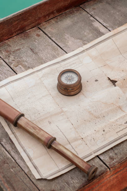 antike nautische navigationsausrüstung mit kompass, teleskop und karte auf holzsegelboot - nautical chart drawing compass map old stock-fotos und bilder