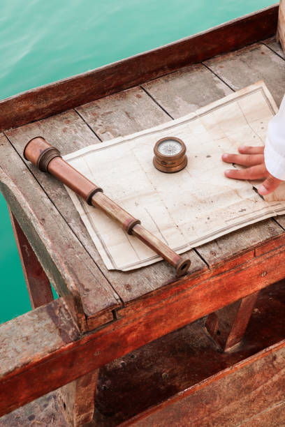 antike nautische navigationsausrüstung mit kompass, teleskop und karte auf holzsegelboot - nautical chart drawing compass map old stock-fotos und bilder