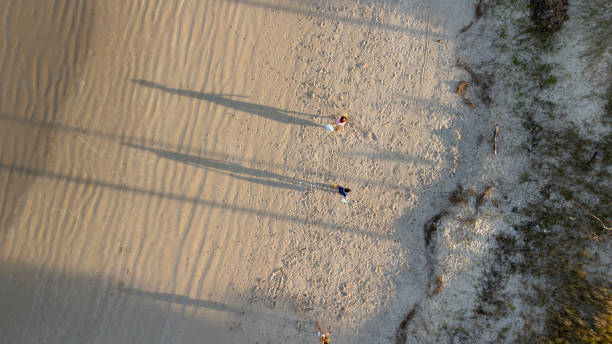 istock People carrying trash bags while walking on the sand 1715646411