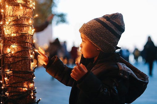Young boy looking at the Christmas decorations on the streets of New York.