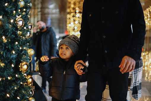 Dad takes his little baby boy for Christmas shopping in New York.