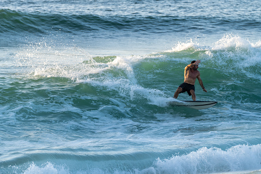 Surfer riding waves in Furadouro Beach, Portugal. Men catching waves in ocean. Surfing action water board sport. people water sport lessons and beach swimming activity on summer vacation.