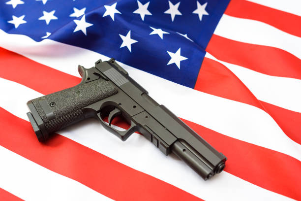 istock Gun over American patriotic flag, firearms restriction debate. 1715670029