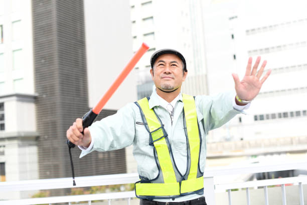 가이드 로드를 들고 있는 중년 아시아 남성 노동자 - flagger 뉴스 사진 이미지