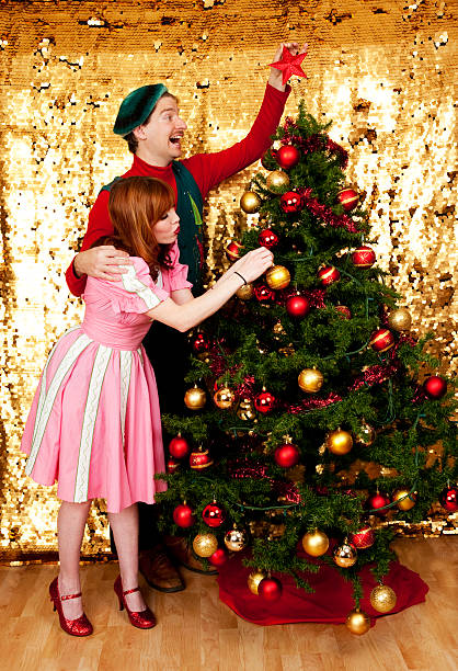 couple décorer un sapin de noël - kitsch men ugliness humor photos et images de collection