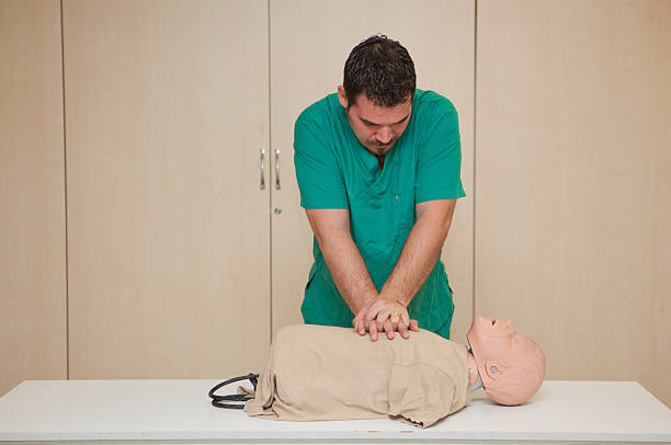 Basic life support training with a CPR Dummy-cardiac massage stock photo