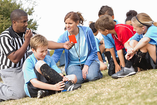 istock Referee and coach helping injured soccer player during kids' game 171571473