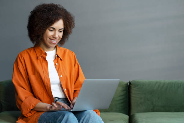 istock African American woman using laptop working online from home. Copywriter typing on keyboard 1715716413