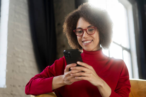 istock Modern female wearing red eyeglasses using mobile app, shopping online, ordering food 1715716975
