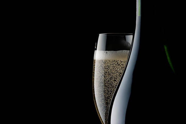 Champagne glass and blank bottle against black background Champagne glass and blank bottle against black background with copy space. champagne flute stock pictures, royalty-free photos & images