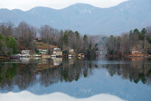 Homes and landscape reflected in the water at Lake Lure, North Carolina