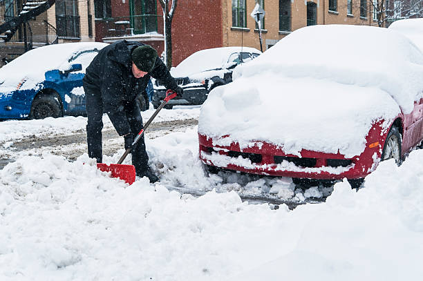 istock Man shoveling around his car on a snowing day. 171571865