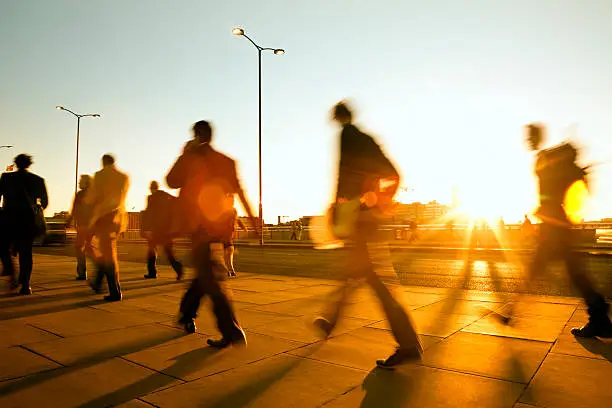 Photo of Blurred people walking in sunset light