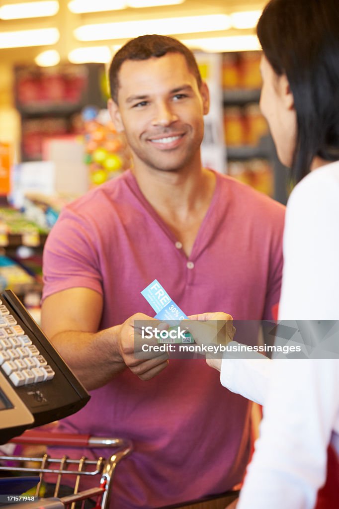 고객 쿠폰을 사용하여 슈퍼마켓 체크아웃하려면 - 로열티 프리 쿠폰 스톡 사진