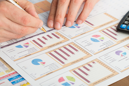 Close-up of male hand with pen working with documentsfinancial results