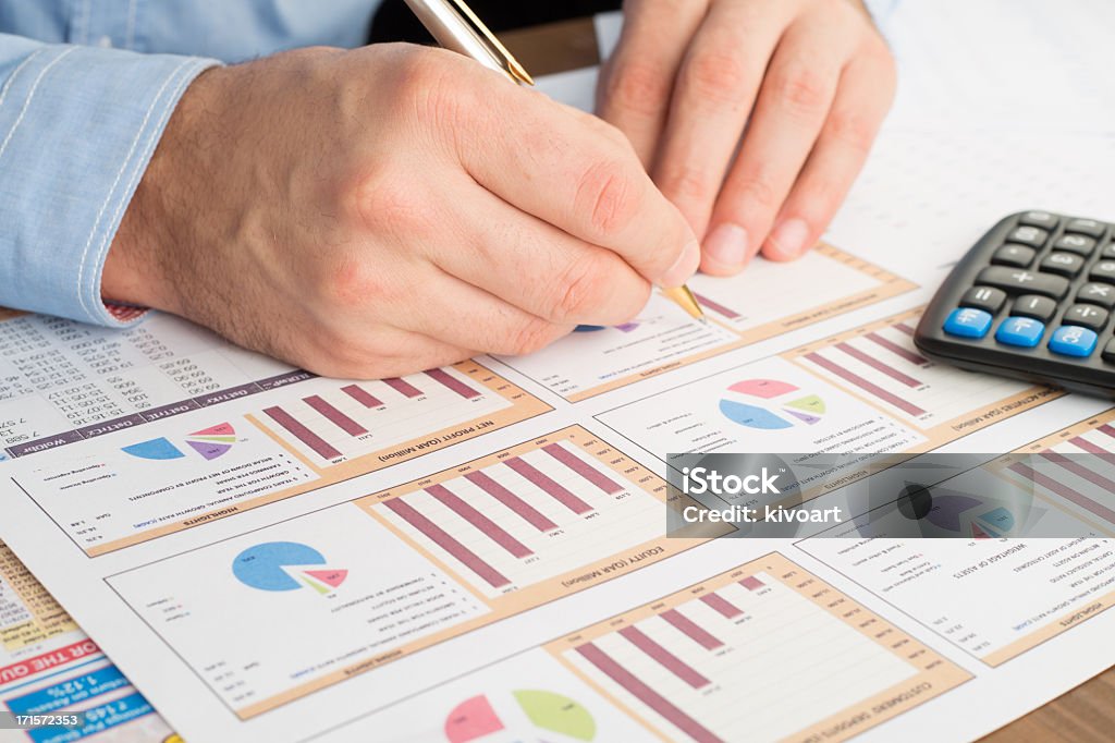 Checking the results Close-up of male hand with pen working with documentsfinancial results Chart Stock Photo
