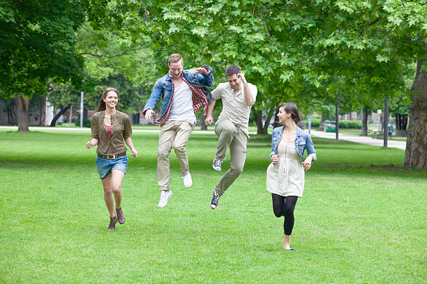 grupa młodych ludzi, bieganie i skakanie w parku - 20s berlin germany heterosexual couple boyfriend zdjęcia i obrazy z banku zdjęć